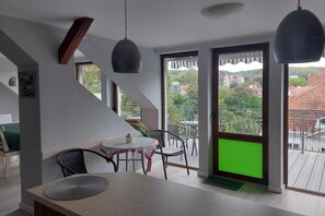 Un interior moderno con comedor, una escalera y un balcón con vistas.