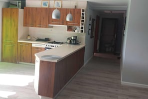 A kitchen with wooden cabinets, a stove, and a microwave.