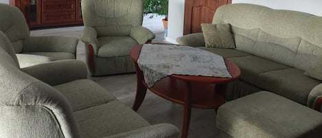 A living room with a sofa set, a coffee table, and a cabinet.