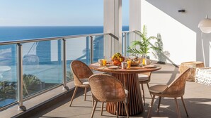 A balcony with a round table, wicker chairs, and a view of the ocean. - Luxury apt in clifftop condo | Palace Ocean View (Funchal)