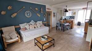 Un salon comprenant un canapé, une table basse et un coin repas avec des chaises.