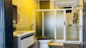A modern bathroom with a toilet, sink, and shower area. - Charming 1-bedroom apartment in Naalya with a serene environment. (Kampala)