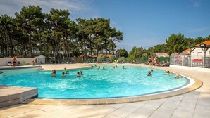 Ein Swimmingpool, umgeben von Bäumen und einer Bar.