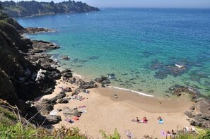 A beach with clear water, rocky shoreline, and people sunbathing. - ZEcamping 4* familial parc aquatique locatif TV BBQ 17m2 2 pers (Saint-Lunaire)