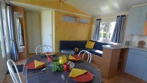 Un espacio habitable compacto con comedor, sofá y kitchenette.