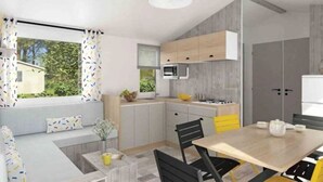 A modern kitchen with a dining area, featuring a built-in microwave, wooden cabinets, and a large window with curtains. - ZEcamping 4* animé piscine couverte dog friendly locatif TV BBQ 36m2 (Saint-Lunaire)