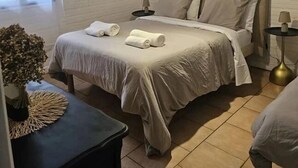 Ein Schlafzimmer mit einem großen Bett, einem Nachttisch, einer Lampe und einer Pendelleuchte.