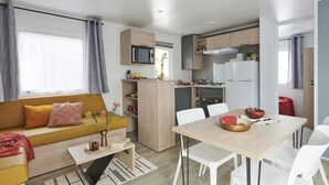 A compact living space with a sofa, dining table, and kitchenette.