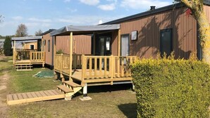 A row of mobile homes with wooden decks and a grassy yard. - ZEcamping 4* familial 500m plage piscine couverte mobil-home TV LV BBQ (Morsalines)