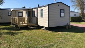 A mobile home with a deck, a satellite dish, and a small porch. - ZEcamping 4 étoiles 500m plage piscine couverte mobil-home TV BBQ 35m2 (Morsalines)