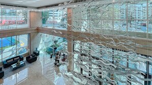 A modern interior with a glass ceiling, large windows, and a seating area with sofas and a coffee table.