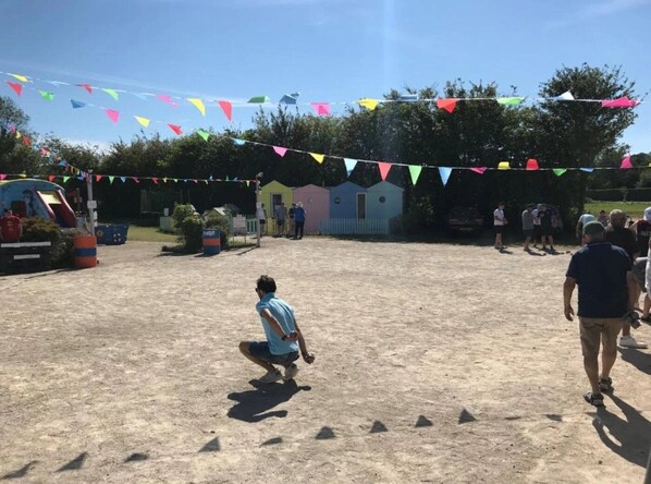 A sandy outdoor area with colorful triangular flags strung overhead.