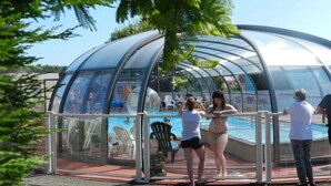 A transparent dome structure with a pool inside, surrounded by a metal railing. - ZEcamping 4 étoiles animé 500m plage piscine couverte mobil-home 25m2 (Morsalines)