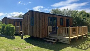 A wooden cabin with a deck, a door, and a window. - ZEcamping 4 étoiles animé 500m plage piscine couverte mobil-home 25m2 (Morsalines)