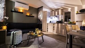 Una sala de estar moderna con un sofá, una mesa de comedor y una zona de cocina al fondo.