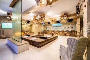 Relax in a serene spa setting with a massage table and comfortable seating.