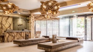 A spacious lobby with a large seating area, a reception desk, and a large window with a view of the outdoors.