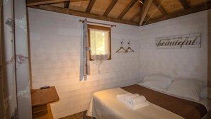 A bedroom with a wooden ceiling, a bed with white bedding, a window with a curtain, and a wall sign that says 'life is beautiful.' - Cabane 4 étoiles - Piscine  - ccabhid (Azur)