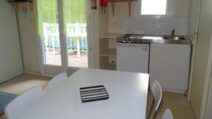 A compact kitchen with a sink, stove, and a small window.