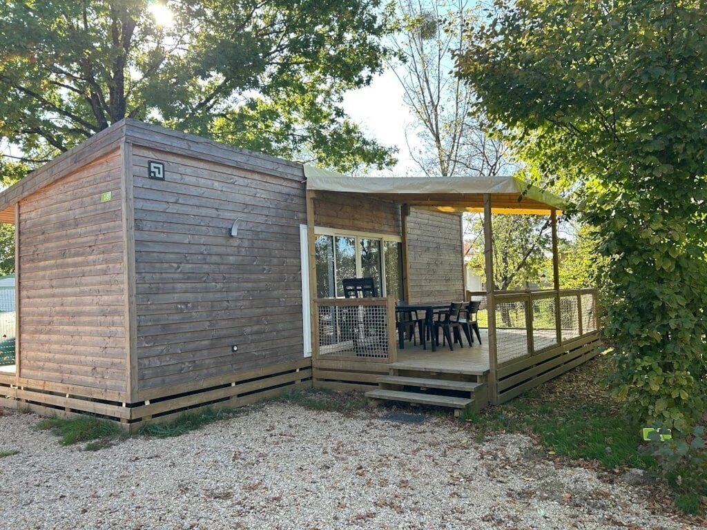 Een houten chalet met terras en zitgedeelte buiten.