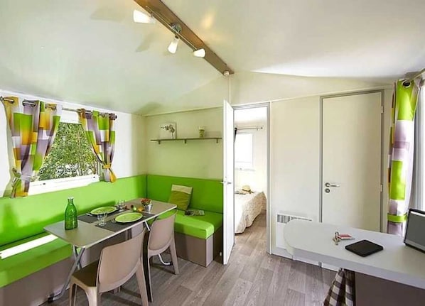 Cozy space with a dining area, seating nook, and shelf for essentials.