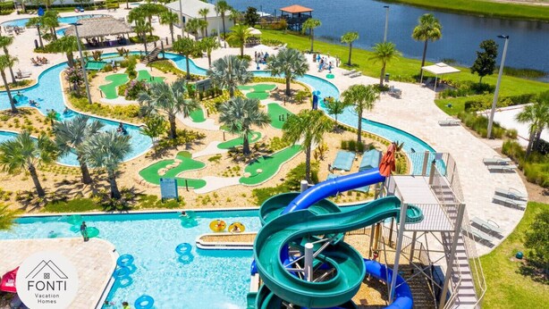 A resort with a water park, including slides and pools, surrounded by palm trees and a body of water. - 3141-104 Resort Lake View Disney Universal Orlando (Kissimmee)