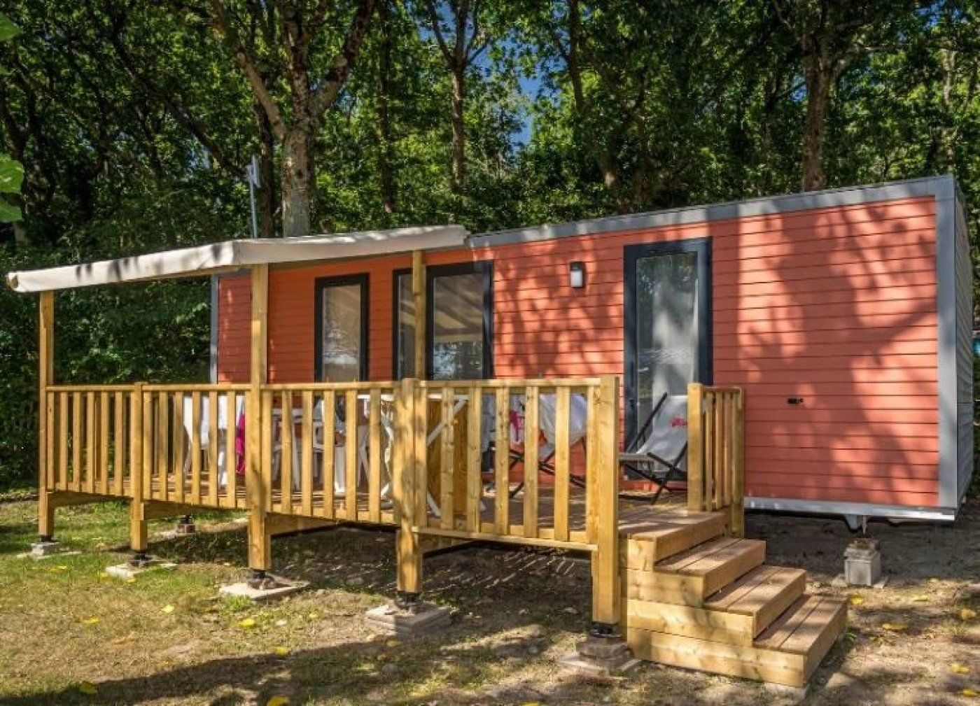 A small cabin with a wooden deck and a porch.