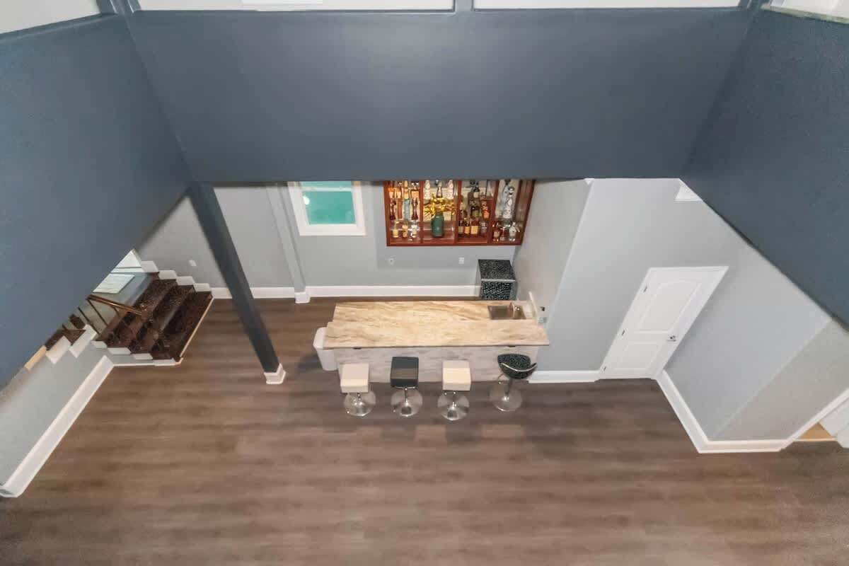 Une cuisine moderne dotée d’un plan de travail en bois, d’un meuble à vin intégré et offrant une vue sur l’espace de vie.
