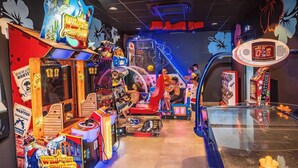 An indoor arcade with various gaming machines, including a shooting game and a racing game.