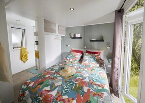 Een slaapkamer met een bed, een raam en een deur.