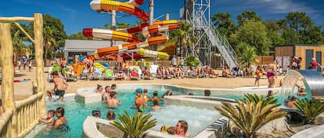 Parque acuático con varias toboganes, piscina y zona de hidromasaje.