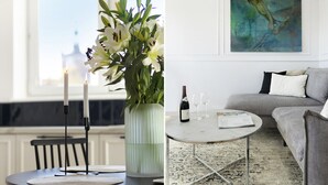 Un coin repas avec une table, des bougies et un vase de fleurs.