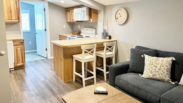 A compact living space with a kitchenette, a dining area, and a sofa. - Your Little Guest House (Kennewick)