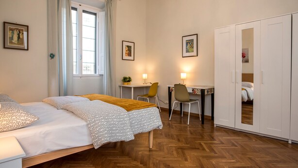 Une chambre à coucher avec un lit, un bureau, une chaise et une armoire.