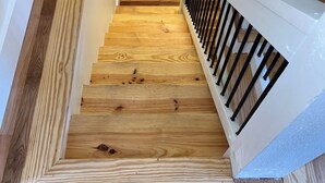 A wooden staircase with white railings and a handrail. - Charming 2-bedroom house with AC, WiFi in the Sky Valley Country Club. (Dillard)