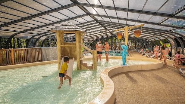An indoor water park with a covered area, slides, and a pool. - ZEcamping familial dog friendly familial piscine couverte (Hourtin)