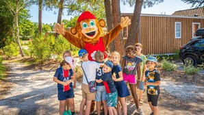 A mascot standing in front of a group of children outdoors. - ZEcamping piscine couverte dog friendly animations tente TV 24m2 (Hourtin)