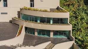 A modern building with a curved facade, large windows, and a rooftop garden. - GuestReady - Fantastic home near the beach (Funchal)