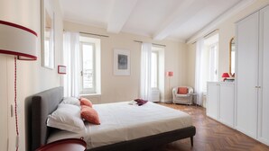 A bedroom with a bed, bedside table, wardrobe, and a chair. - Coppelle Charme - Three Bedroom Apartment, Sleeps 6 (Rome)