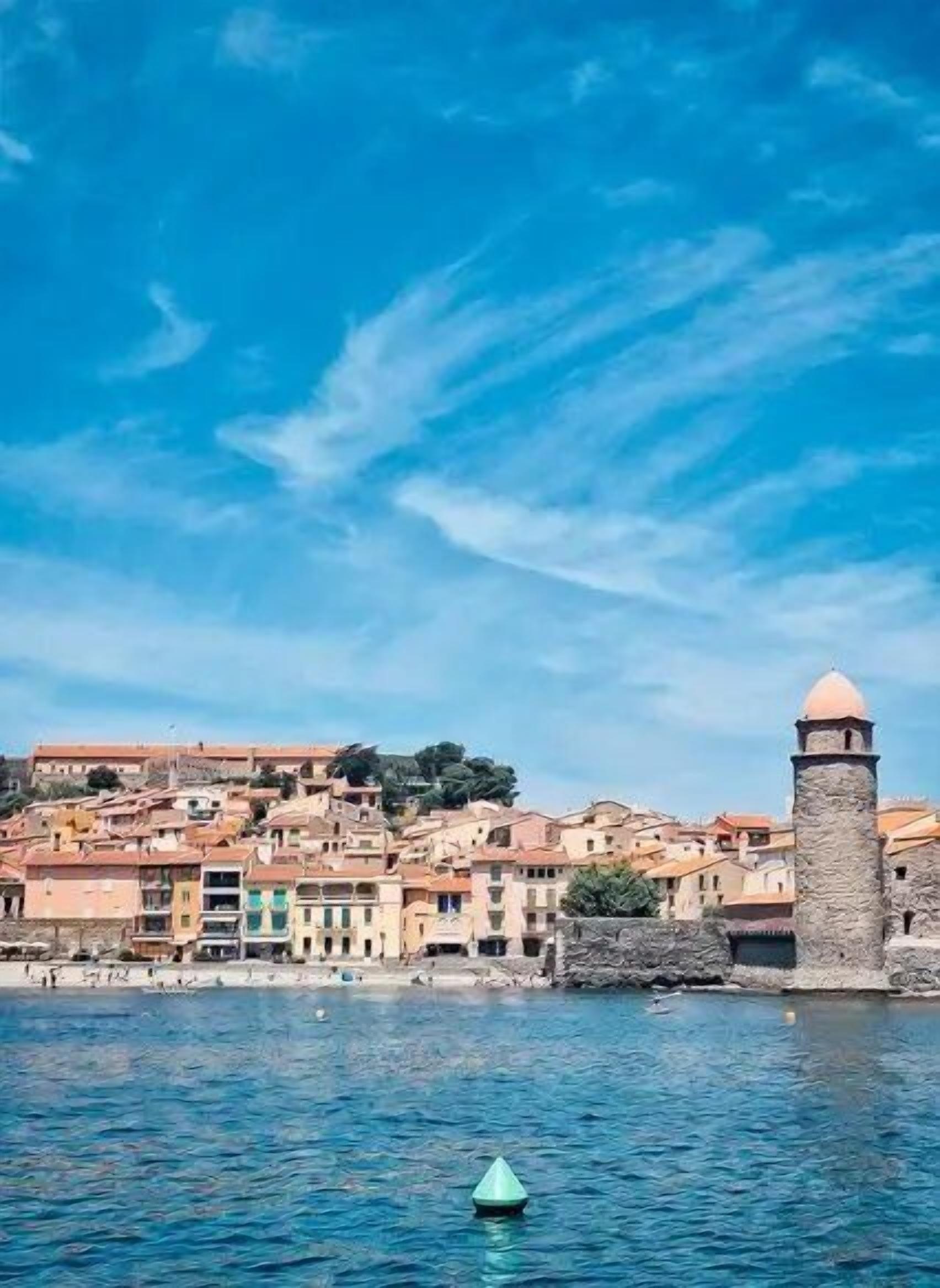 Une ville côtière dotée de bâtiments historiques et d’un imposant édifice qui domine la mer.