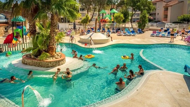 A large outdoor swimming pool with multiple lanes, surrounded by lounge chairs and umbrellas. - ZEcamping animé espace aquatique dog friendly locatif TV clim 4 pers (Argeles-sur-Mer)