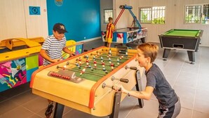 A room with a foosball table, a pool table, and a colorful mural on the wall. - ZEcamping animé espace aquatique dog friendly locatif TV clim 4 pers (Argeles-sur-Mer)