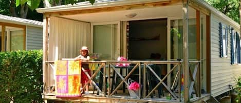 Une maison mobile dotée d’un balcon, d’un vélo et d’une petite terrasse.