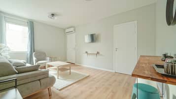 Deluxe Quadruple Room | Living area | TV