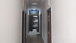 A hallway with a central painting, recessed lighting, and a tiled floor. - Hotel A.D. Residency By Reverie (Agra)