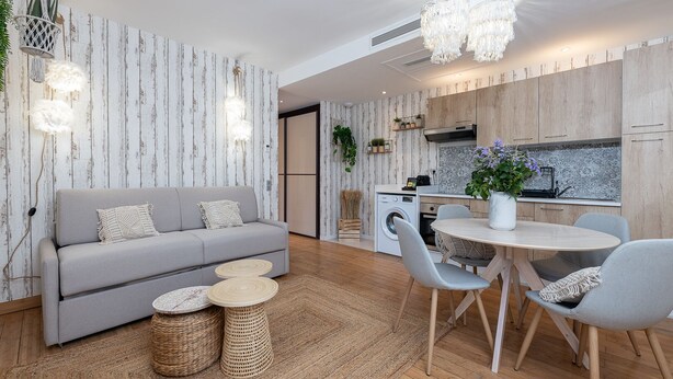 A modern living room with a grey sofa, round coffee table, and a dining area with a round table and chairs. - Garden Apartment La Bohémienne, Mandara Beach (Antibes)