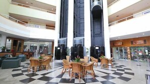 A spacious lobby with a checkered floor, multiple seating areas, and a central staircase. - Flat no Tropical Executive Hotel (Manaus)