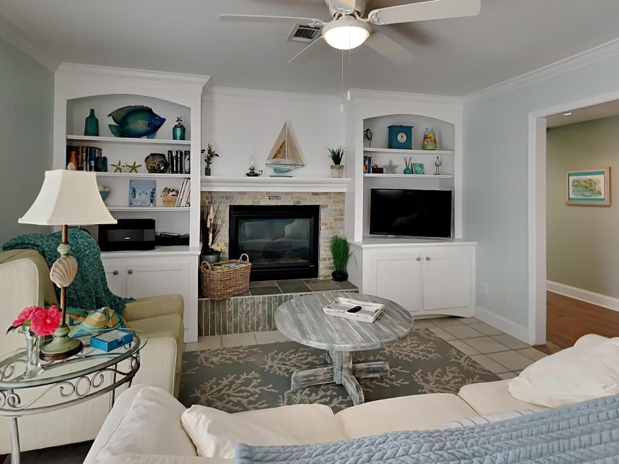 Una sala de estar con chimenea, televisor y zona de estar.
