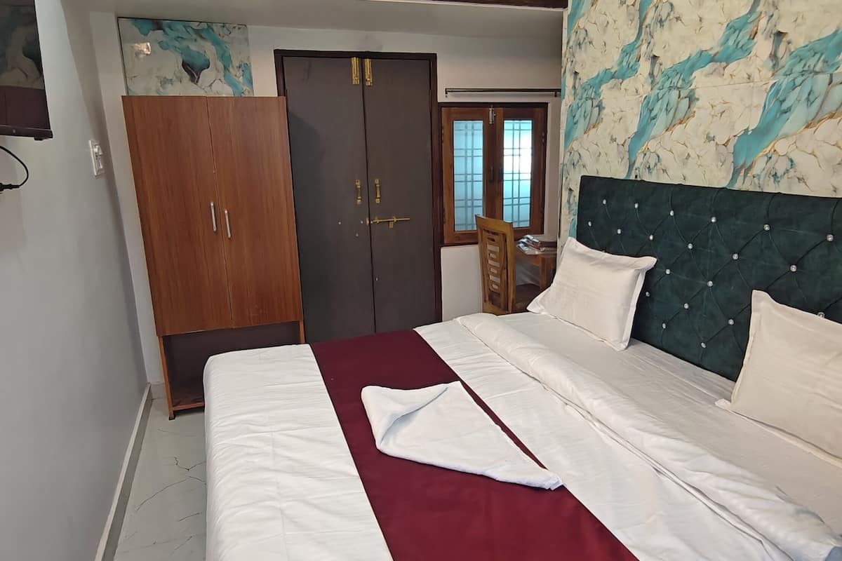 A bedroom with a bed, a wardrobe, and a door.