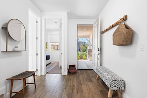 A hallway with a bench, a mirror, and a woven basket on the wall. - 5 Bed Modern St George Oasis! (Washington)